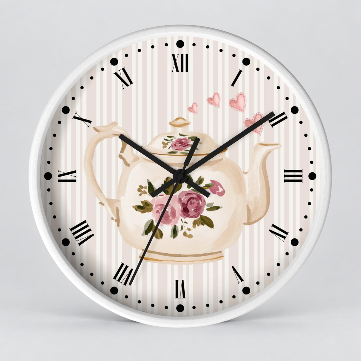 Round wall clock with a white frame, featuring a vintage-style floral teapot illustration on a cream and pink striped dial with black Roman numerals and hands.