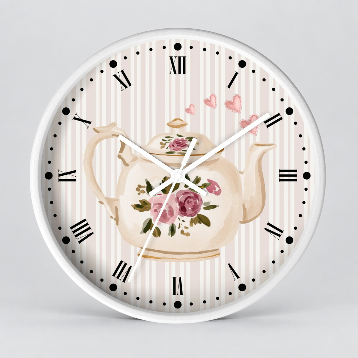 Round wall clock with a white frame and a floral teapot design on the face, featuring pink roses, green leaves, a cream striped background, black Roman numerals, and white clock hands.
