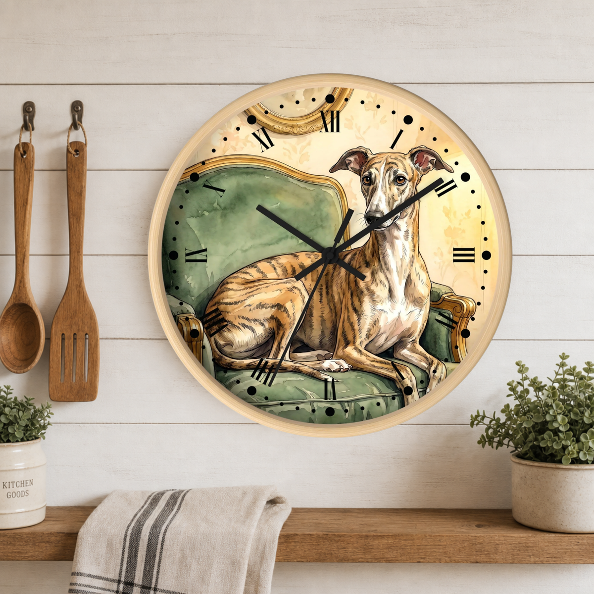 A round wall clock with a vintage illustration of a greyhound dog sitting on a green armchair, displayed on a white wood-paneled wall above a shelf with kitchen utensils and plants.