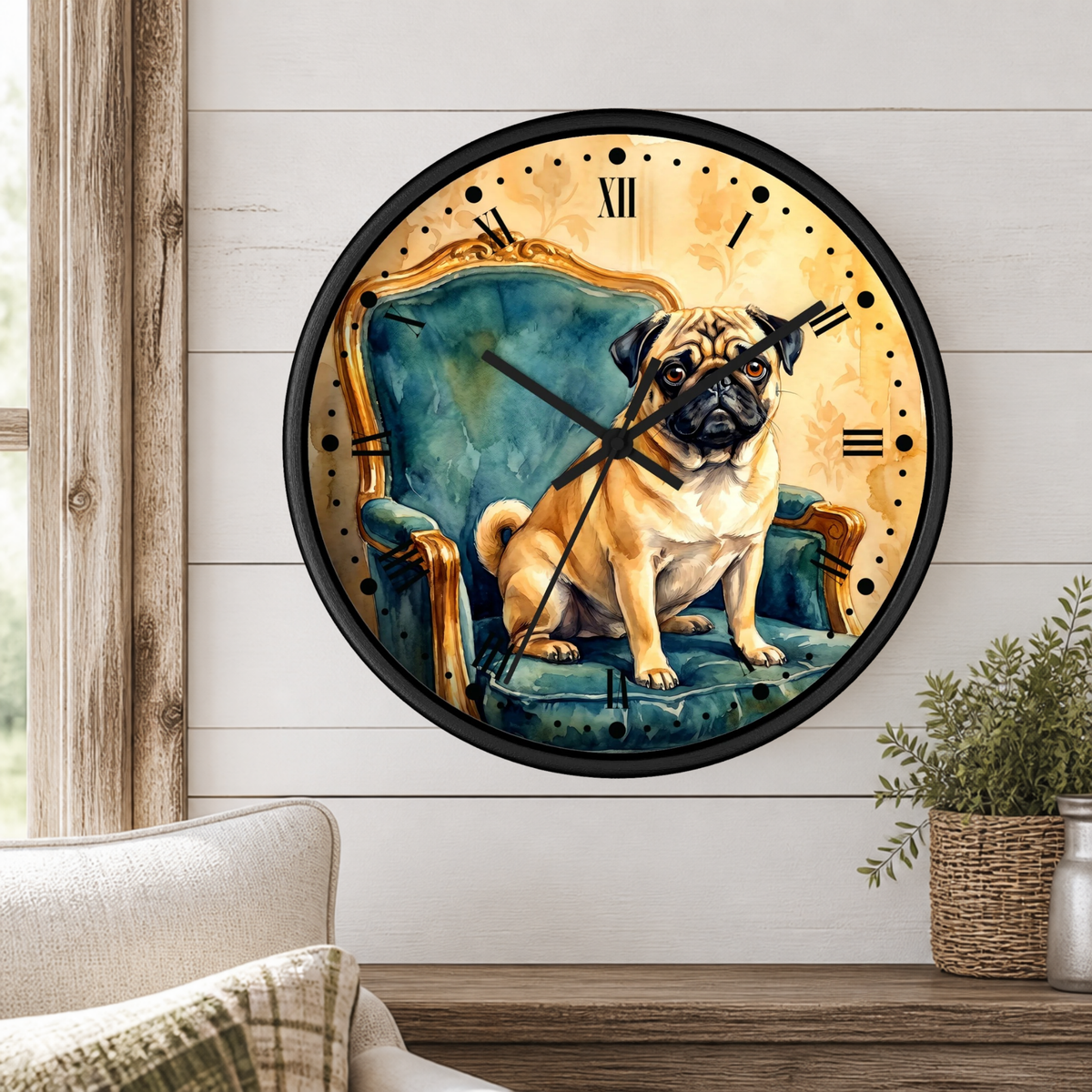 A round wall clock with a black frame and a printed illustration of a pug sitting in a teal armchair, mounted on a white shiplap wall above a wooden table with a plant and part of a sofa visible.