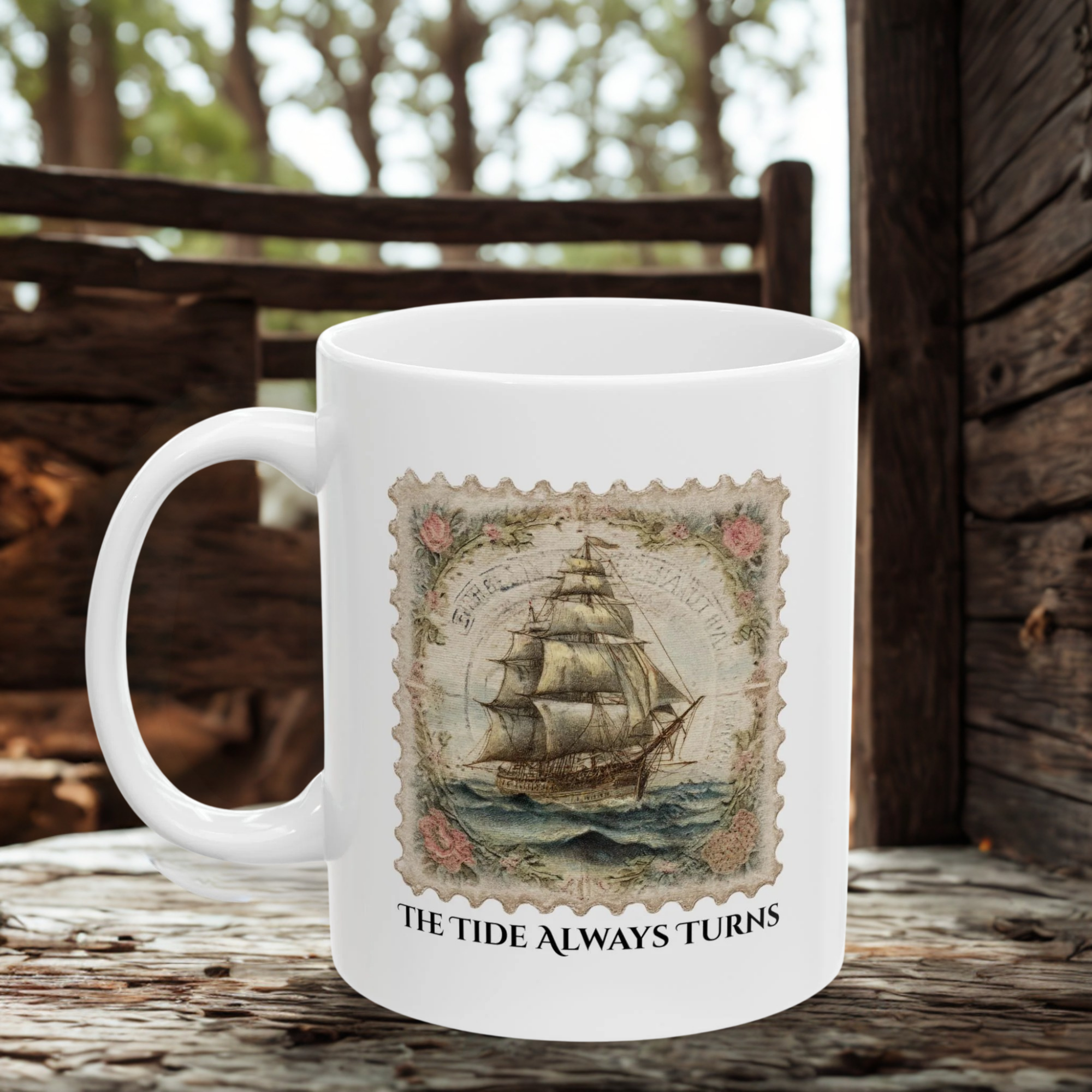 White mug with a ship design and 'The Tide Always Turns' text on a wooden surface.