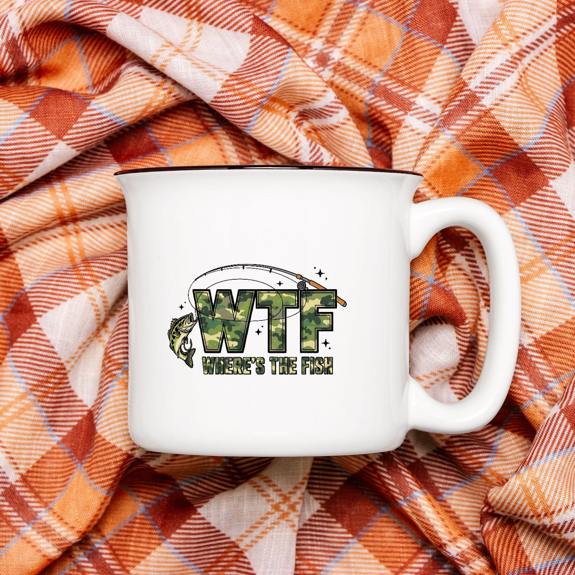 White 13oz. camp mug with 'WTF Where's the Fish?' text on a plaid fabric background