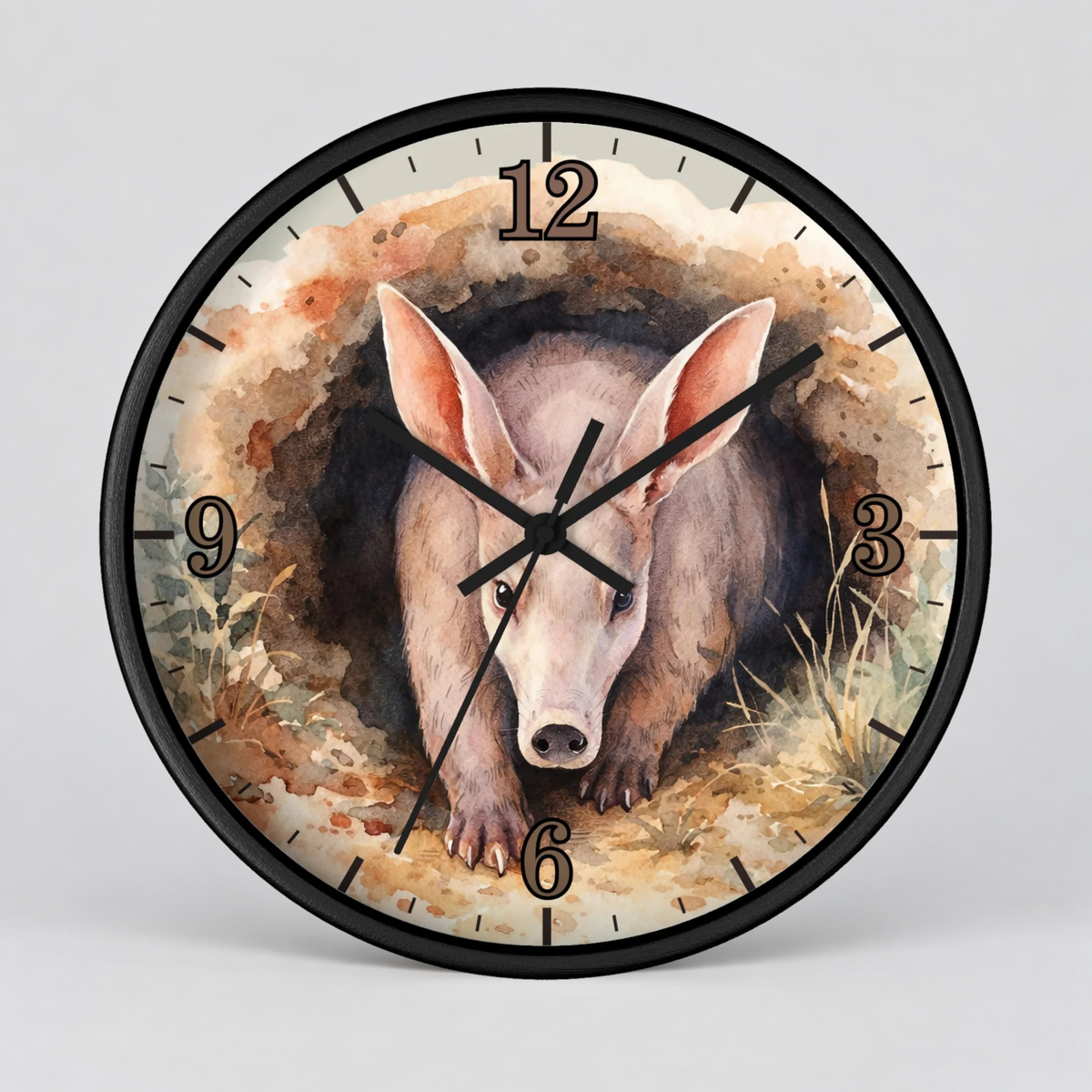 Round wall clock with a black frame and a watercolor-style illustration of an anteater emerging from a hole at the center. The clock face has black numerals and black hands, shown against a light gray background.