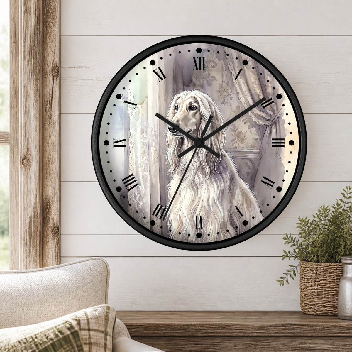 A round wall clock with a black frame and a printed illustration of a long-haired white dog on the face, mounted on a white shiplap wall above a wooden table with a plant and part of a chair visible.