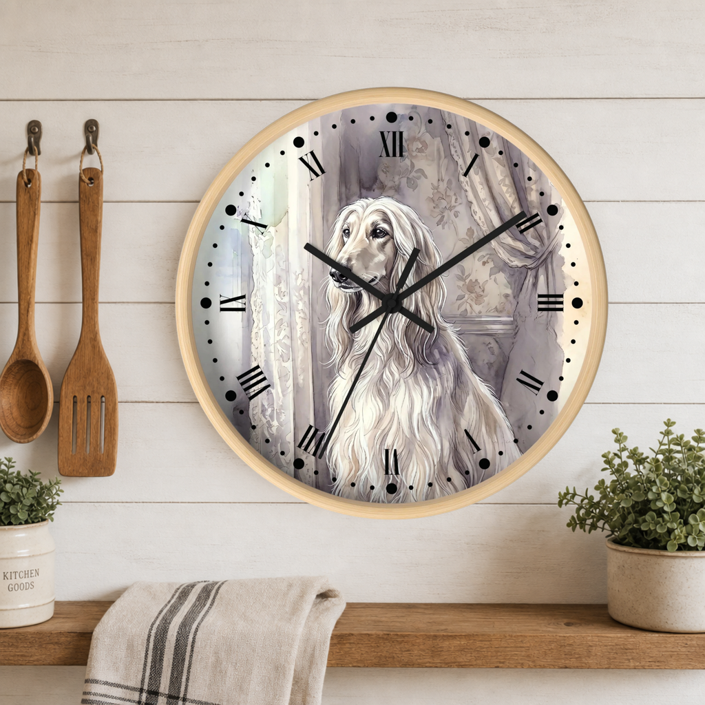 Round wall clock with a light wood frame featuring a grayscale illustration of a long-haired dog, mounted on a white wood-paneled kitchen wall above a shelf with plants and utensils.