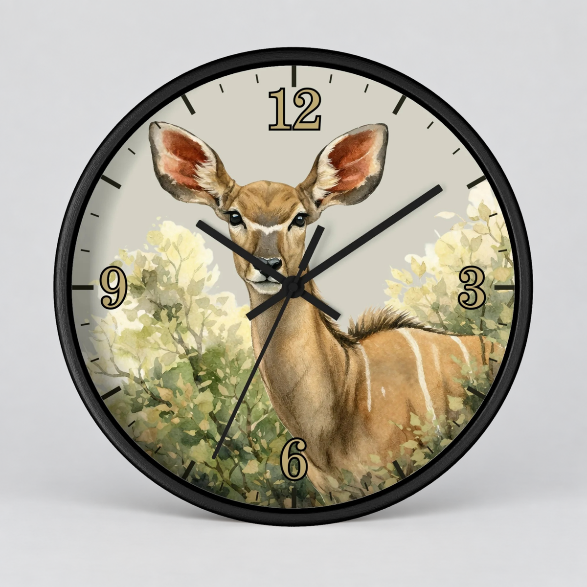 A round wall clock with a black frame and a printed illustration of a greater kudu among green foliage on the face, with gold Arabic numerals and black hands, shown against a light gray background.