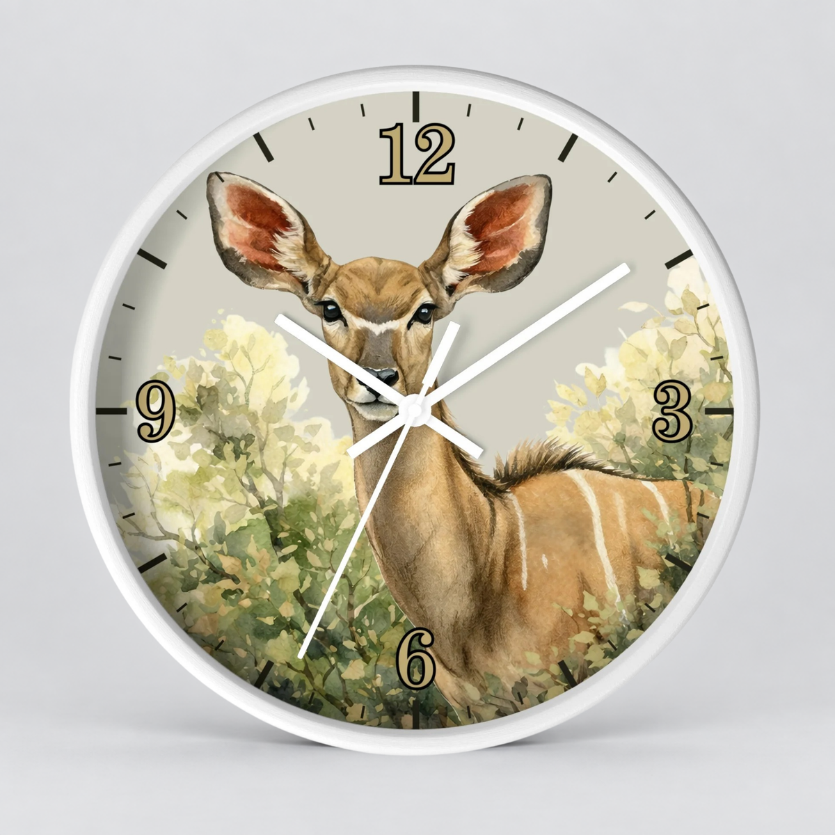 A round wall clock with a white frame and a printed illustration of a kudu deer among green foliage on the clock face, with black Arabic numerals and white hands, shown against a light gray background.