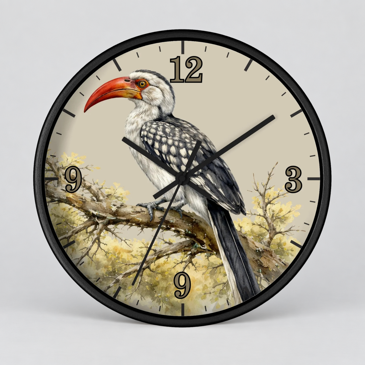 A round wall clock with a black frame and a printed bird illustration on the face. The design shows a black-and-white bird with a bright red-orange beak perched on a branch against a light beige background, with black numerals and black clock hands.