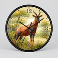 Round wall clock with a black frame and a printed safari scene featuring a topi antelope on the clock face, with black hands and Arabic numerals.
