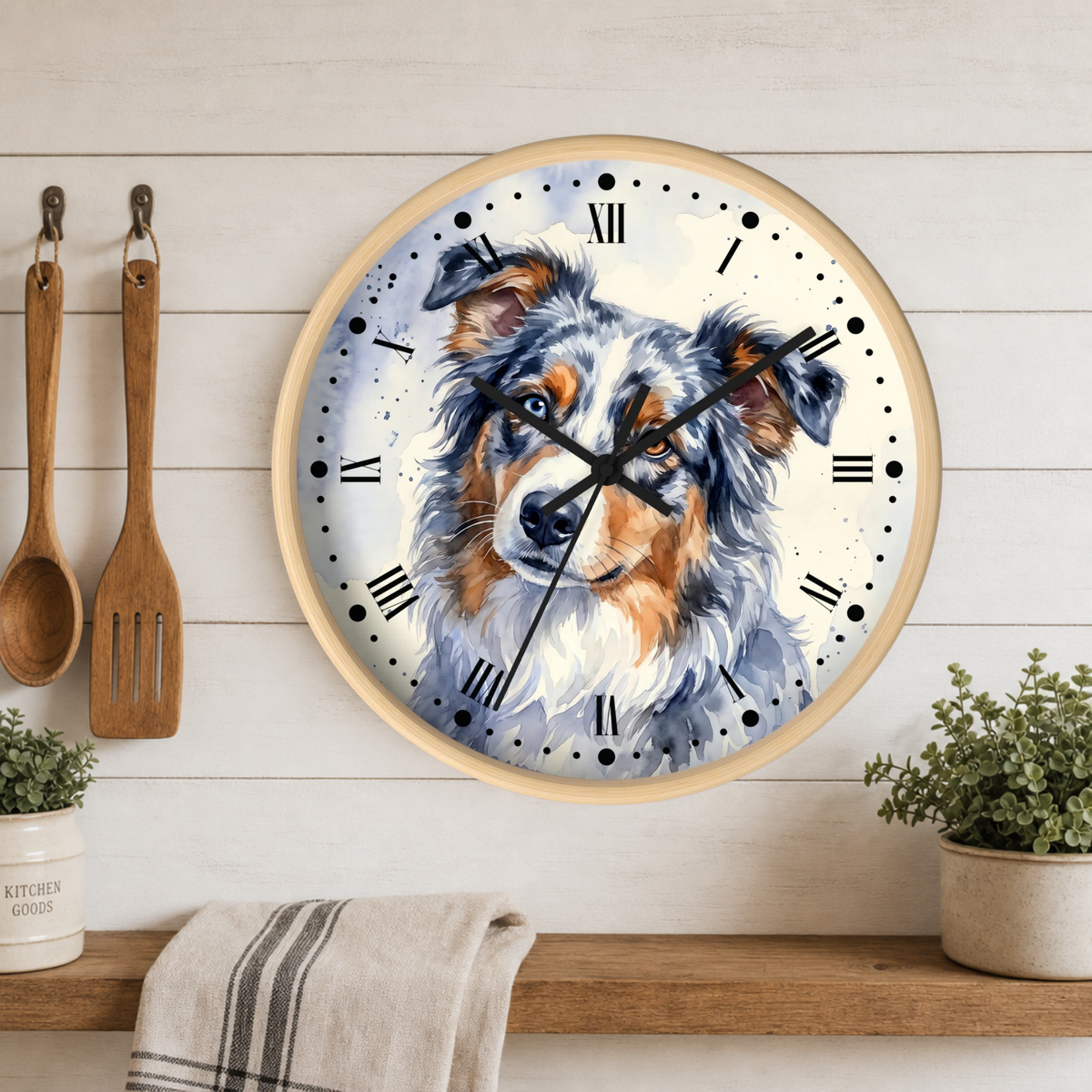 Round wall clock with a watercolor dog portrait on the face, mounted on a white wood plank wall above a wooden shelf with plants and kitchen utensils.