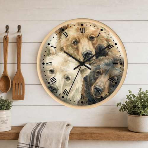 Round wall clock with a light wood frame and a printed design of three bear faces, displayed on a white wood plank wall above a wooden shelf with kitchen utensils and plants.