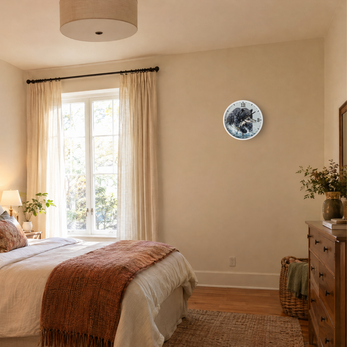 A round wall clock with a blue and white bear design hangs on a beige wall in a styled bedroom with a bed, window, and wooden dresser.