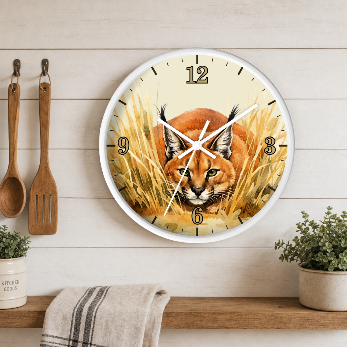 A round wall clock with a white frame and a printed illustration of a carolina fox in golden grass, mounted on a white wood plank wall above a wooden shelf with kitchen utensils and small plants.