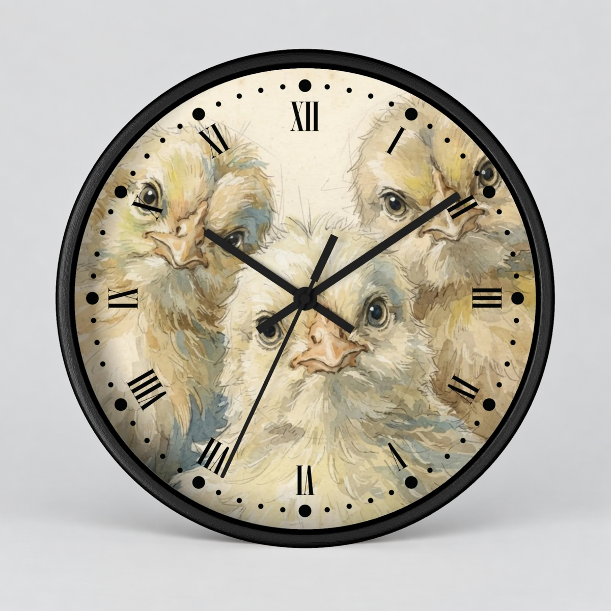 Round wall clock with a black frame and a printed dial featuring three fluffy baby chicks on a light cream background, with black Roman numerals and hands, shown against a light gray studio background.