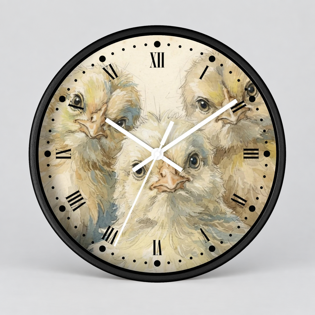 Round wall clock with a black frame and a printed face showing several close-up views of a fluffy cream-colored chick. The clock has black Roman numerals, white hands, and is photographed against a light gray background.