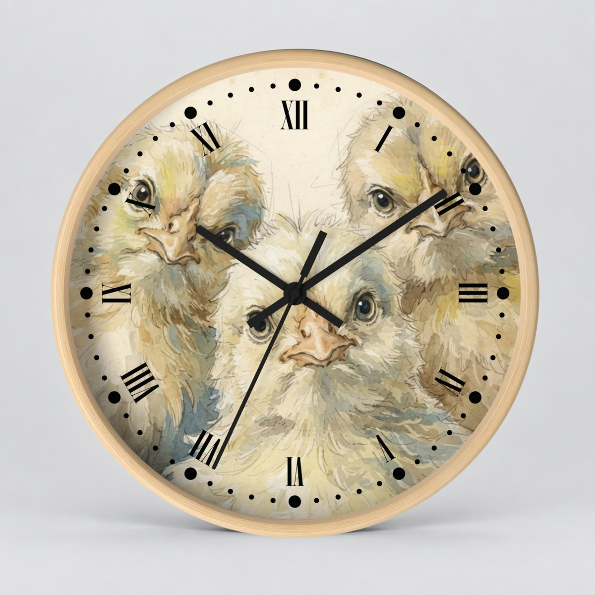 Round wall clock with a light wood frame and a printed dial featuring three fluffy chicks in soft cream, beige, and pale blue tones. Black Roman numerals and black clock hands are visible against a light gray studio background.