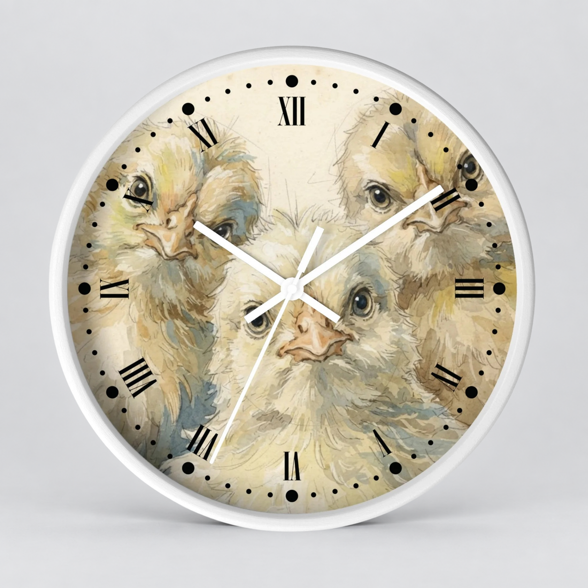 A round wall clock with a white frame and a printed dial featuring three soft-textured baby chicks in cream, beige, and light blue tones. The clock has black Roman numerals and white hands on a light gray background.