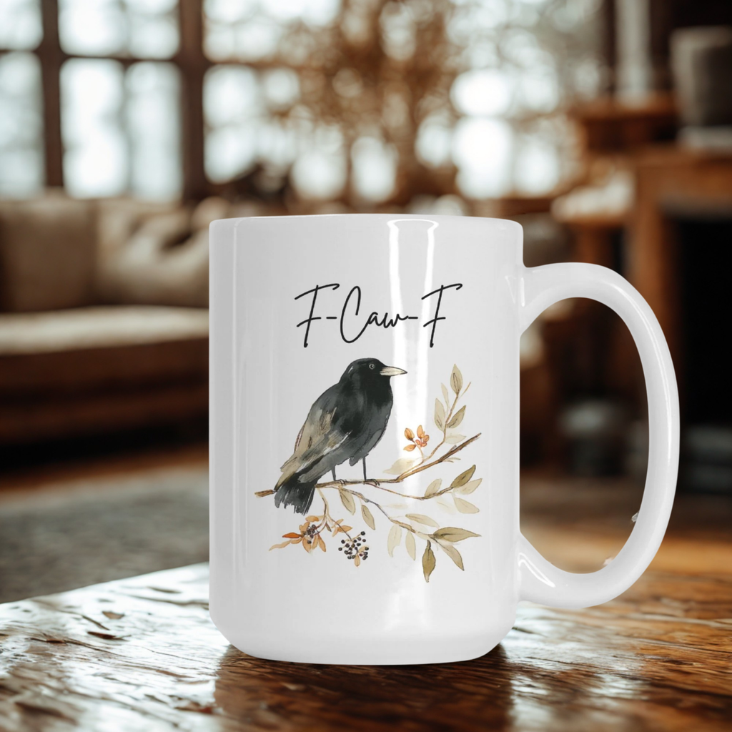 White mug with a bird illustration and 'F-Caw-F' text on a wooden table.