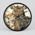 A round wall clock with a black frame and a printed illustration of three deer heads on the face. The clock has black Roman numerals and black hands, photographed against a light gray studio background.