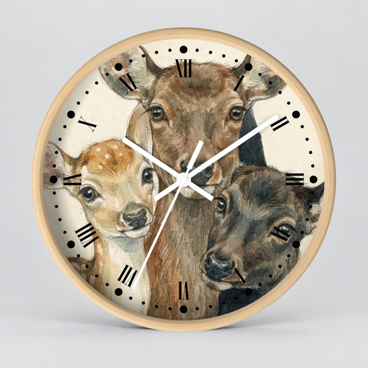 A round wall clock with a light wood frame and a printed illustration of three deer on the face, with white clock hands and black Roman numerals, shown against a light gray background.