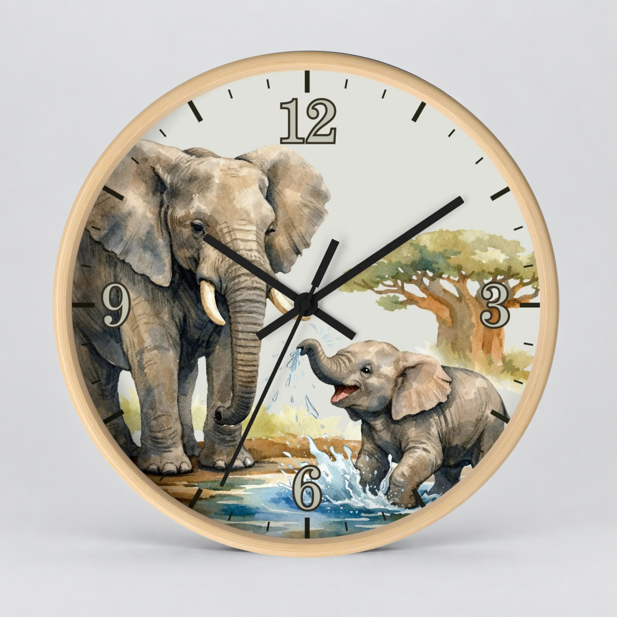 A round wall clock with a light wood frame and a printed illustration of two elephants in a watering landscape. The clock face is off-white with black Arabic numerals and black hands, photographed against a neutral light gray background.