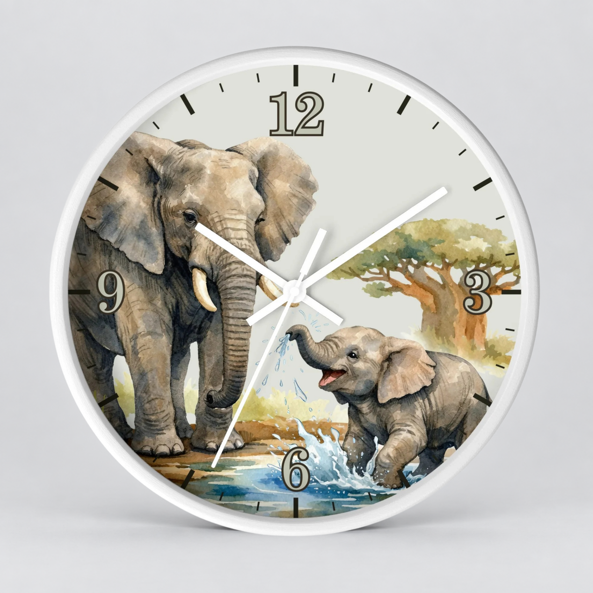 A round wall clock with a white frame and a printed safari scene on the face, featuring two gray elephants, a tree, and a light gray background. The numbers 1 through 12 are printed around the clock face, and the hands are white.