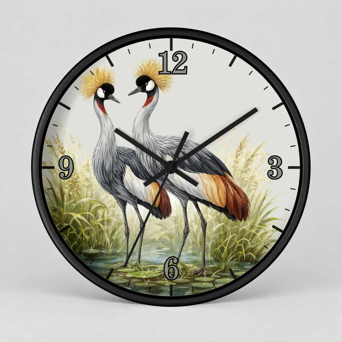 Round wall clock with a black frame and a printed illustration of two crowned cranes standing in a marshy landscape. The clock face is off-white with black numerals and black hands, photographed against a light gray studio background.