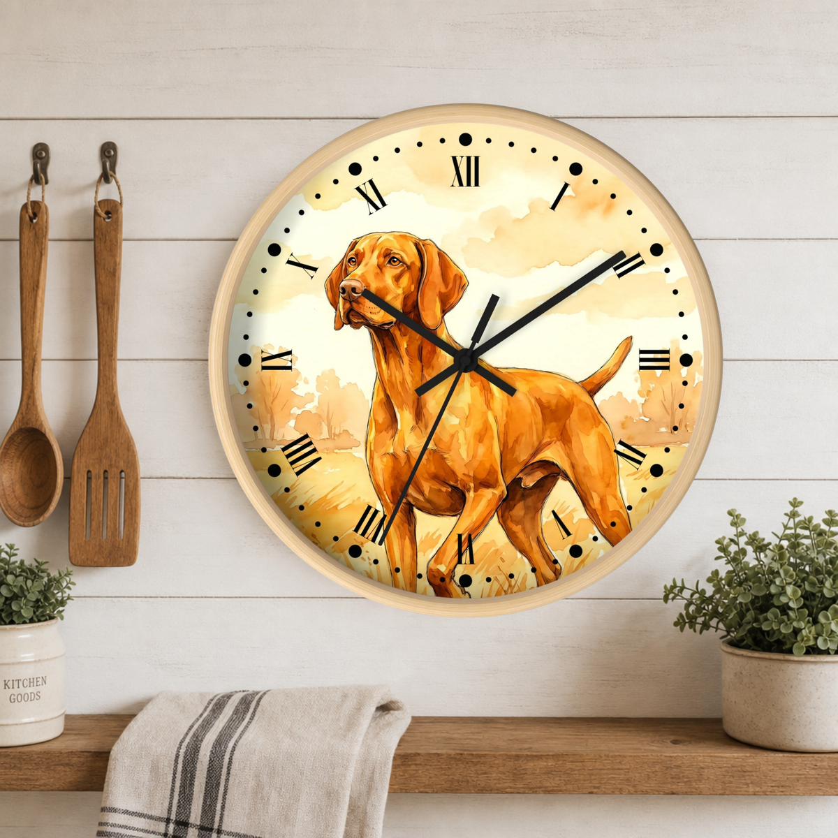 Round wall clock with a watercolor-style Vizsla dog illustration on the face, mounted on a white wood plank wall above a wooden shelf with kitchen utensils, plants, and a towel.