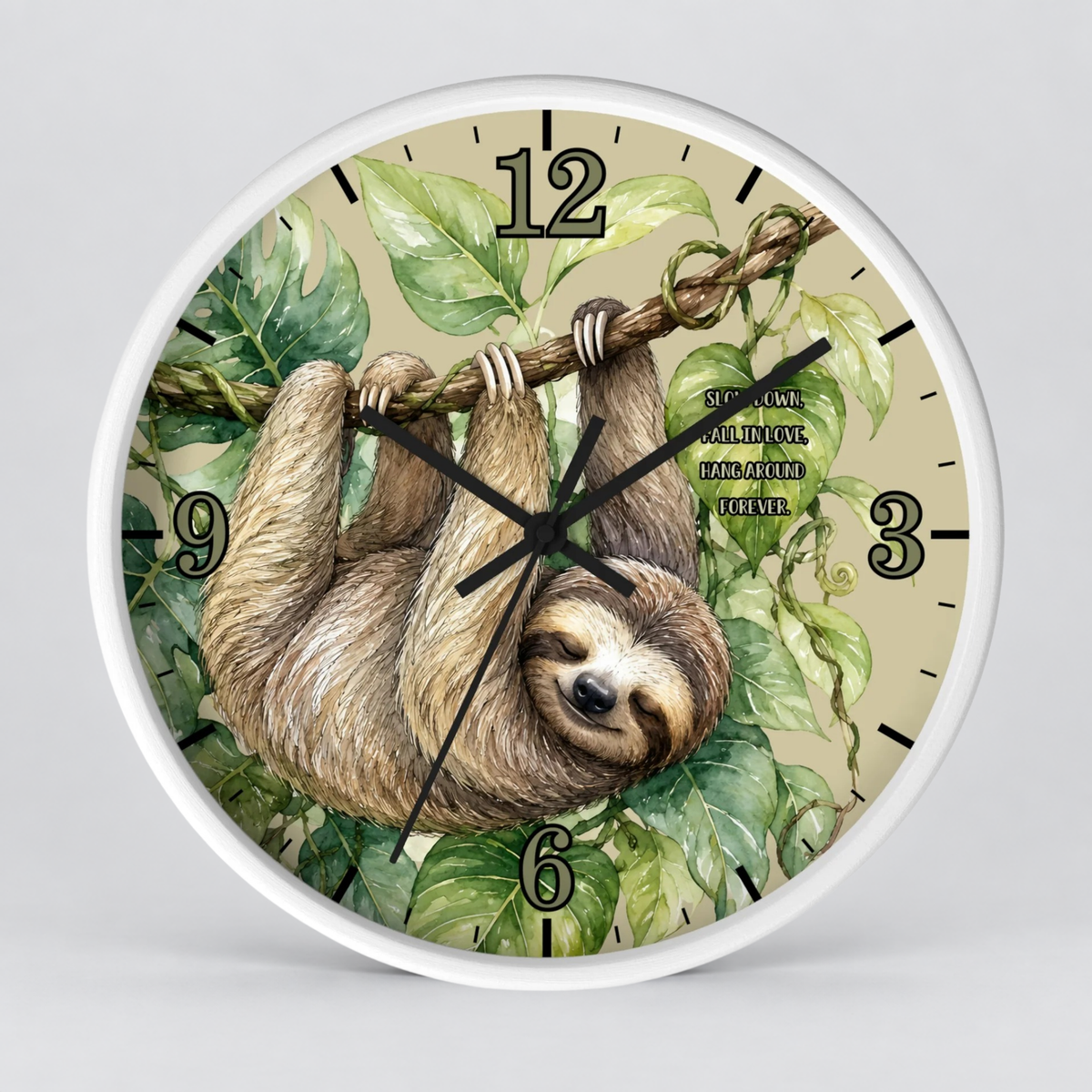 A round wall clock with a white frame and a printed face showing a sloth hanging from a branch among green leaves. The clock has black hands, black hour markers, and a light beige background.