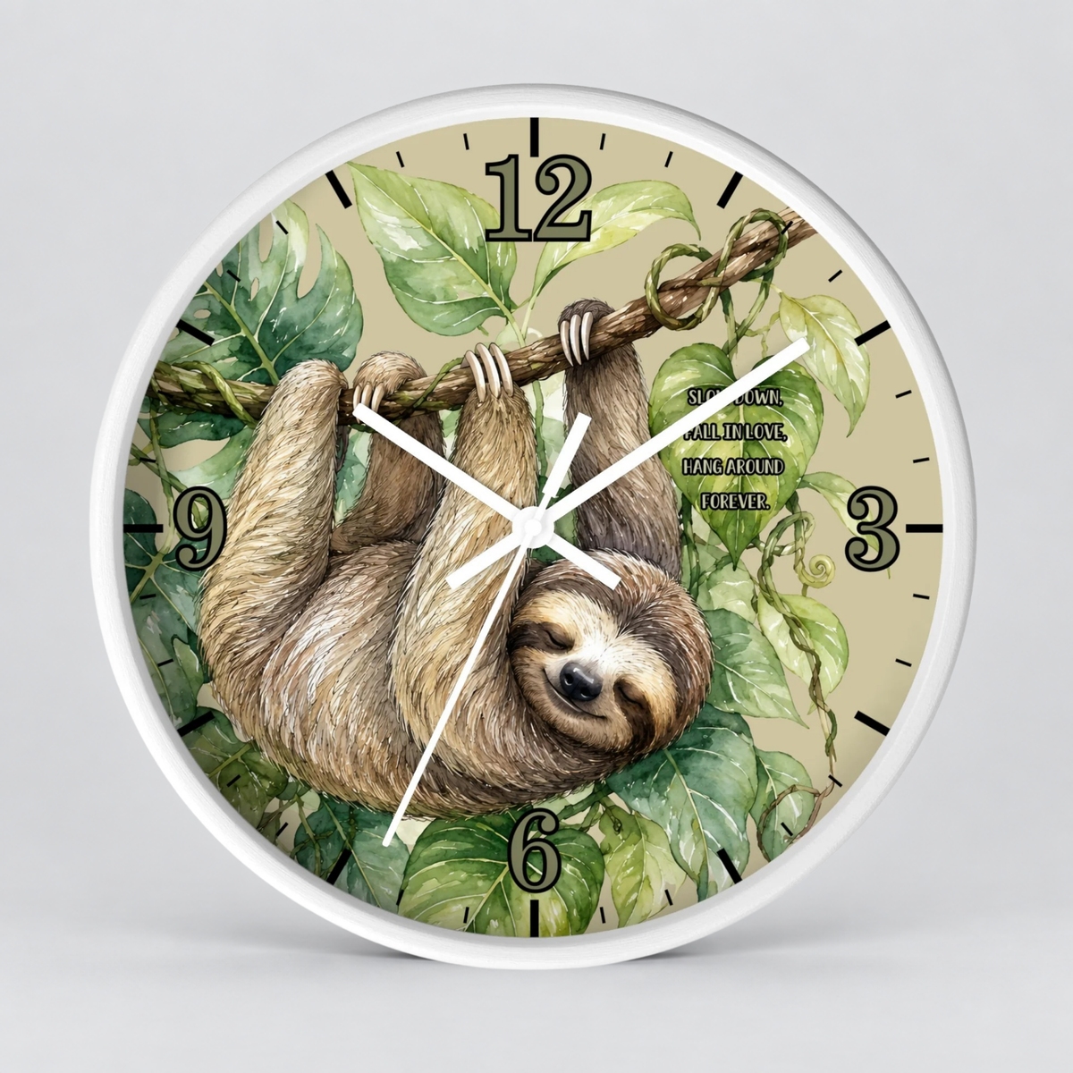 Round wall clock with a white frame and a printed illustration of a sloth hanging from a tree branch among green leaves on a beige background, with black Arabic numerals and white clock hands.