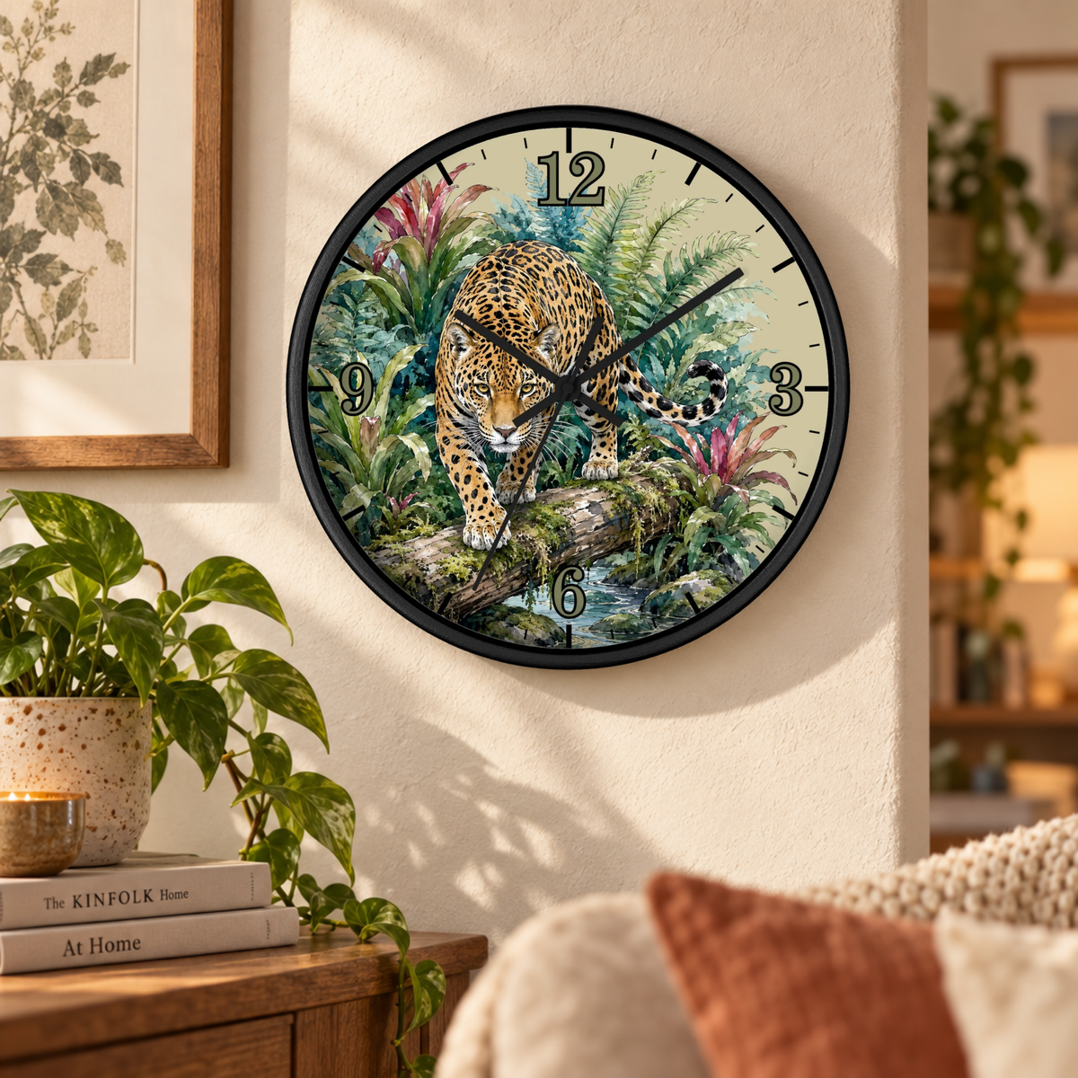 A round wall clock with a black frame hangs on a beige wall in a cozy room. The clock face features a detailed illustration of a leopard walking through lush green tropical foliage.