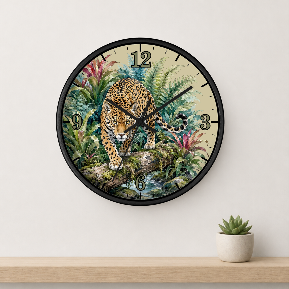 A round wall clock with a black frame and a detailed jungle illustration featuring a leopard walking on a log. The clock is mounted on a white wall above a light wood shelf with a small potted succulent.