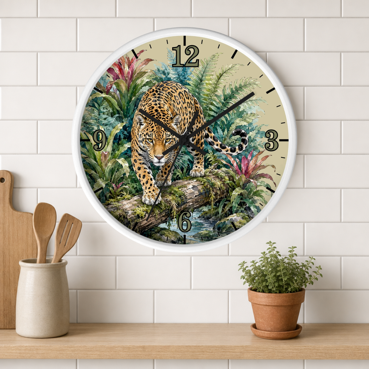 A round wall clock with a white frame hangs on a white subway-tile wall above a wooden shelf. The clock face features a detailed illustration of a leopard walking over a log in a lush green jungle, with black Arabic numerals and black clock hands.