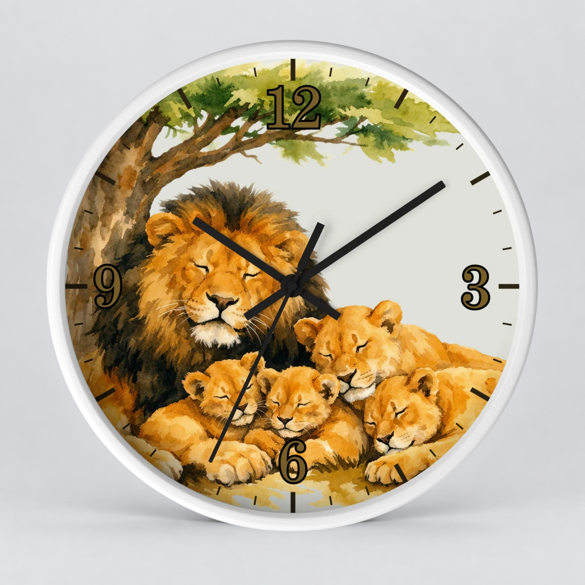 Round wall clock with a white frame and a printed illustration of a lion family under a tree. The clock face shows a golden lion and three lion cubs beneath green leaves, with black Arabic numerals and black clock hands on a light gray background.