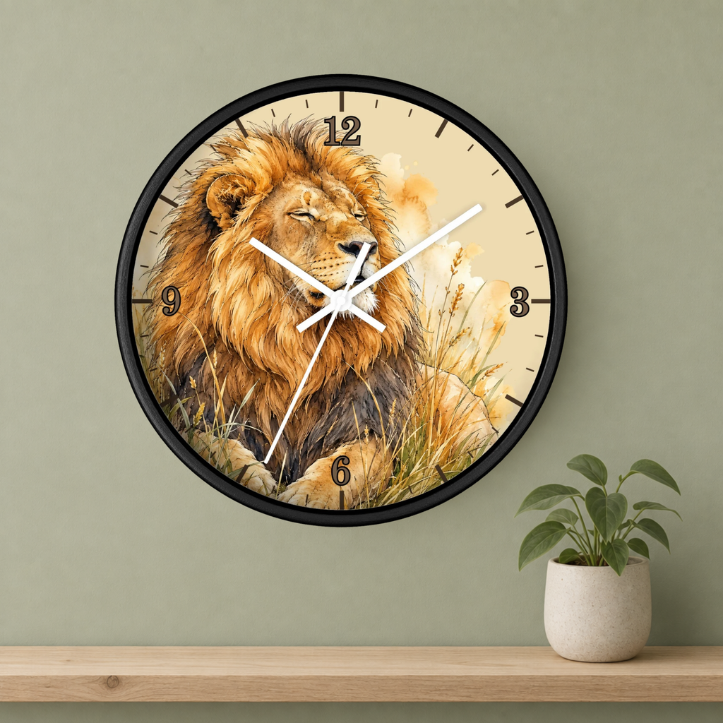 A round wall clock with a black frame and a printed lion illustration, mounted on a sage green wall above a wooden shelf with a small potted plant.