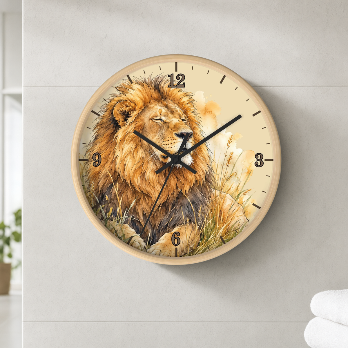 Round wall clock with a detailed lion illustration on the face, mounted on a light gray wall. The clock has a light wood frame, black hands, and black Arabic numerals.