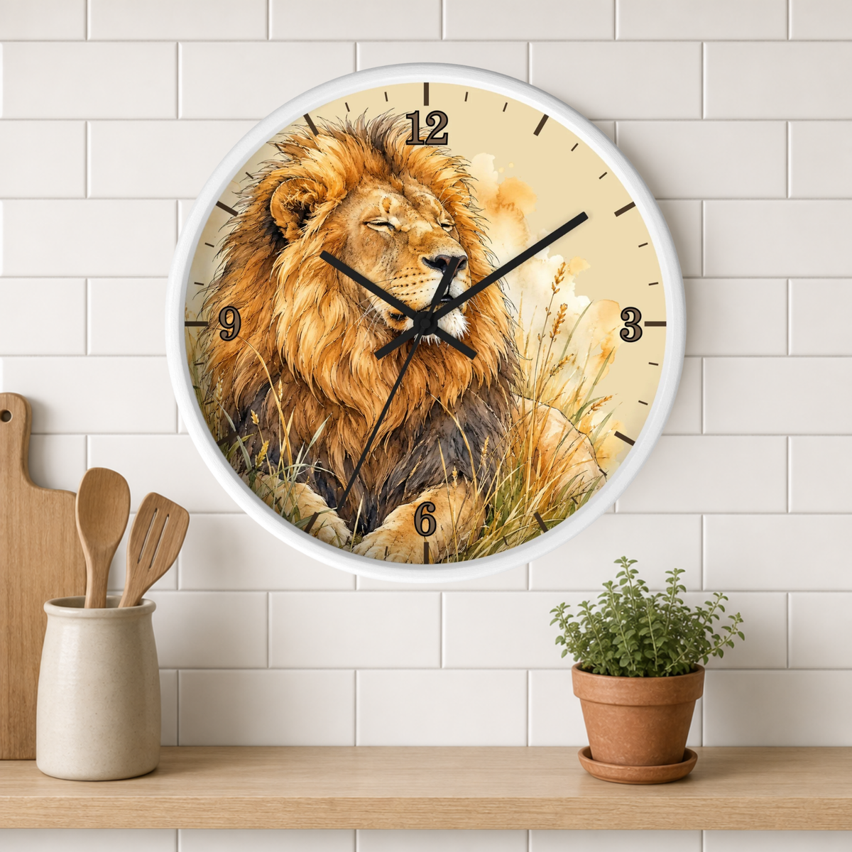 A round wall clock with a white frame and a printed lion illustration, mounted on a white subway tile wall above a wooden shelf with a small potted plant and wooden utensils.