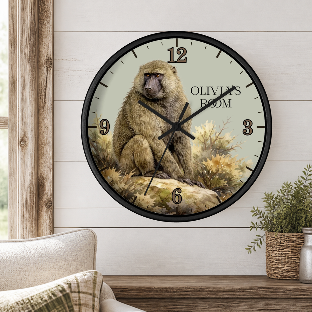 A round wall clock with a black frame and a printed illustration of a baboon on the face, mounted on a white shiplap wall above a wooden mantel with a small plant.