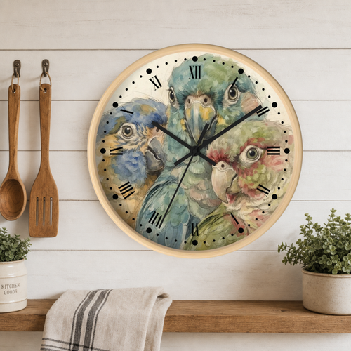 Round wall clock with a light wood frame and a watercolor-style parrot illustration, hanging on a white wood-paneled wall above a wooden shelf with plants and kitchen utensils.
