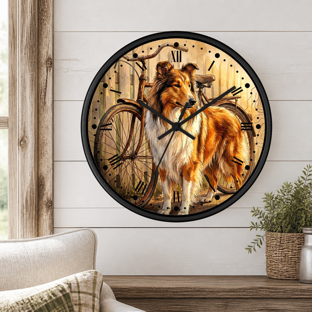 A round wall clock with a black frame and a printed illustration of a collie dog standing in front of vintage bicycles, mounted on a white shiplap wall above a wooden table with a plant and part of a sofa visible.