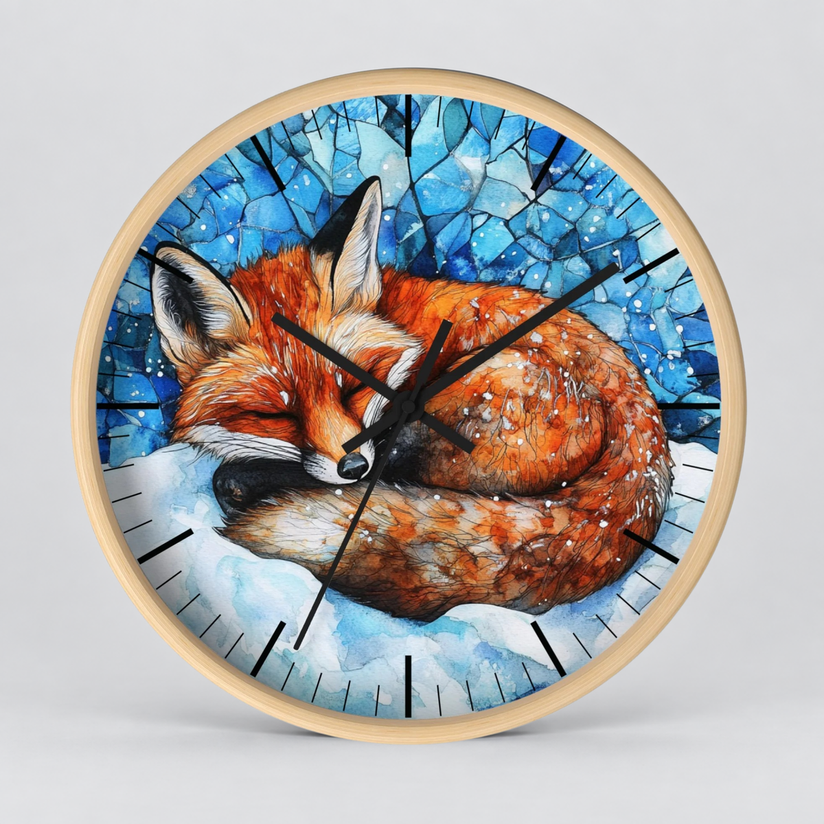Round wall clock with a light wood frame featuring a painted sleeping fox in a snowy blue winter scene, shown against a light gray background.