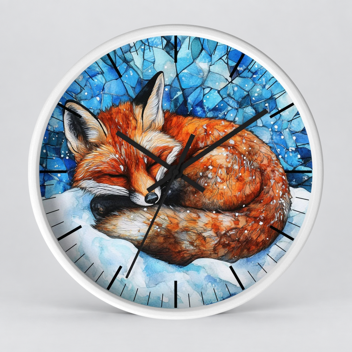 Round wall clock with a white frame and a printed illustration of a sleeping orange fox curled up in white snow against a blue icy background. The clock has black hands and black hour markers.