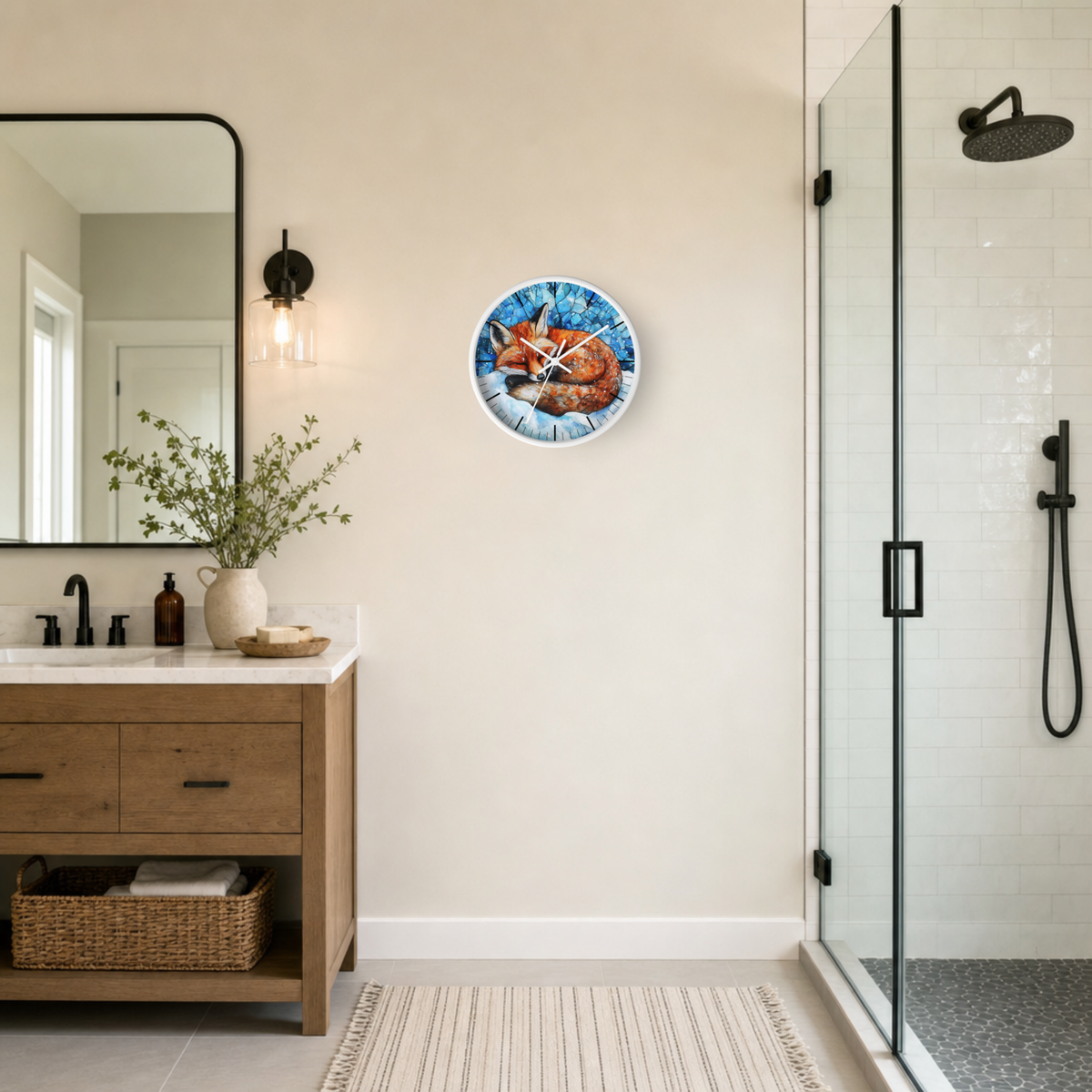 A round wall clock featuring an illustration of a sleeping fox on a blue background, mounted on a beige wall in a modern bathroom next to a wooden vanity and a glass shower enclosure.