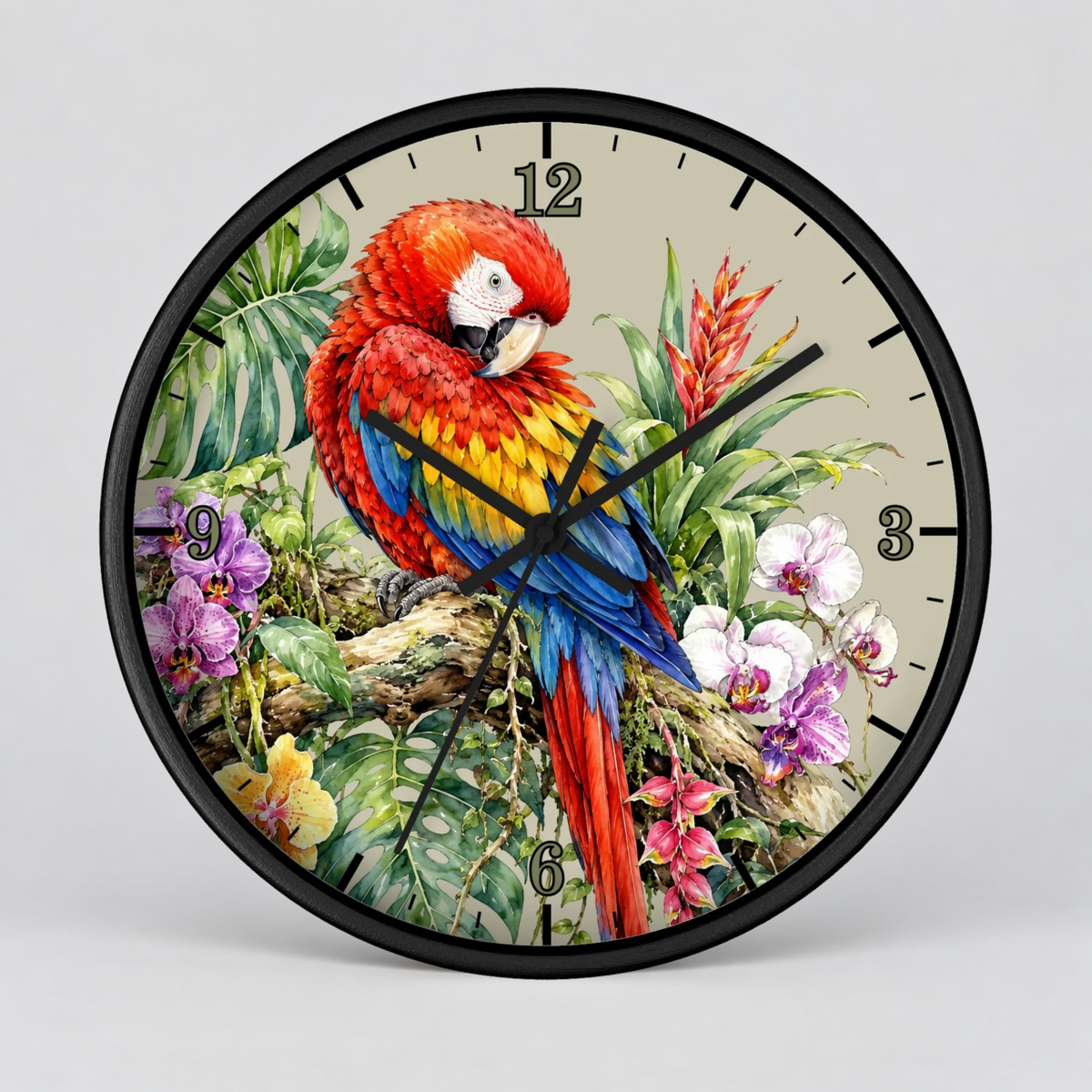 A round wall clock with a black frame and a tropical parrot illustration on the face. The clock features a red, yellow, and blue macaw perched among green leaves and colorful flowers, with black Arabic numerals and black clock hands, shown against a neutral gray background.