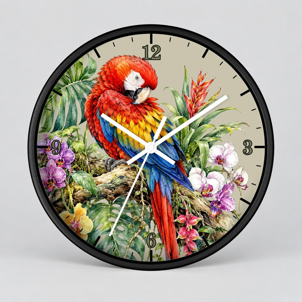 A round wall clock with a black frame and a tropical parrot illustration on the face. The clock features a vibrant red, yellow, and blue parrot among green leaves and flowers, with black Arabic numerals and white clock hands, shown against a neutral gray background.