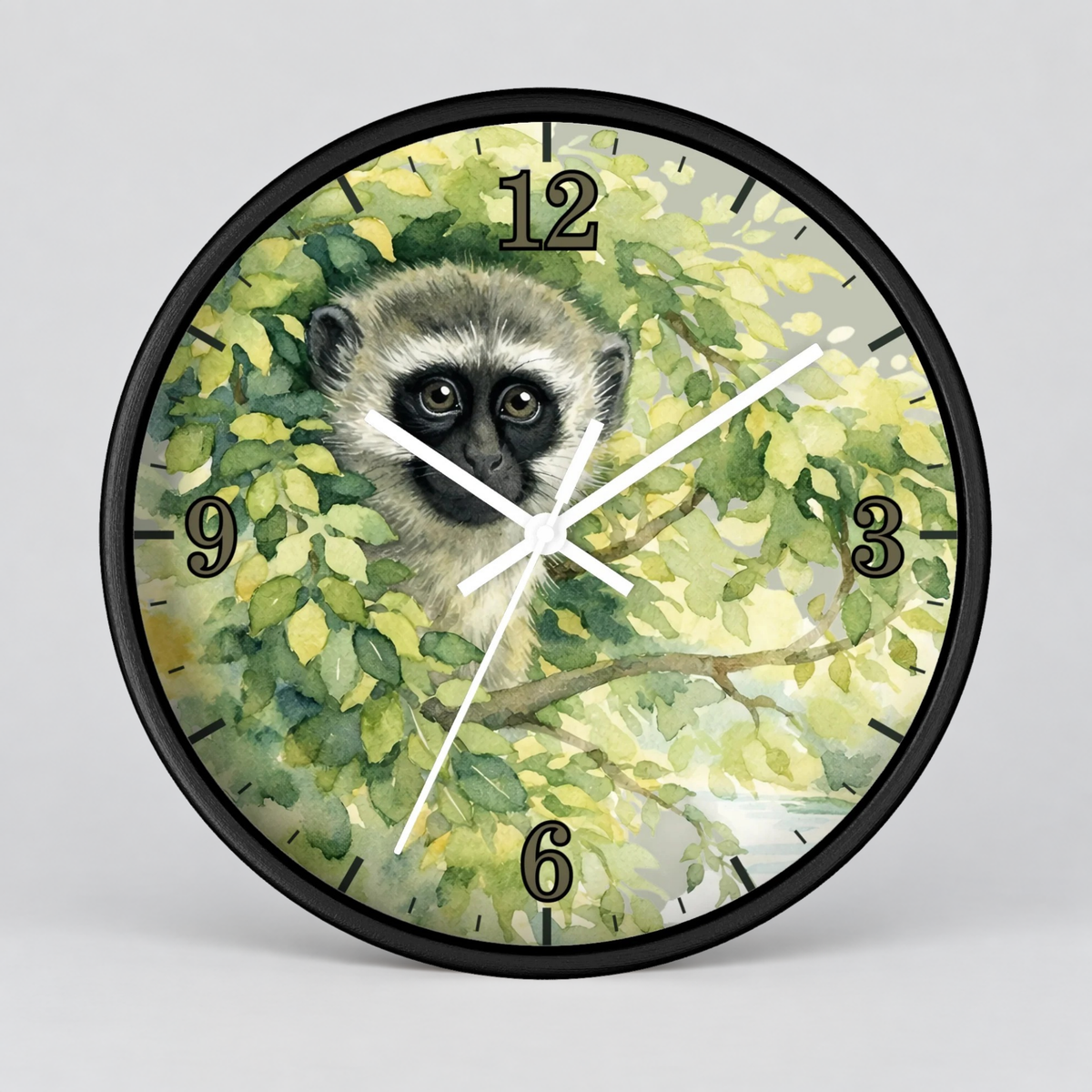 A round wall clock with a black frame and a printed illustration of a vervet monkey among green leaves, with black Arabic numerals and white hands, shown on a light gray background.