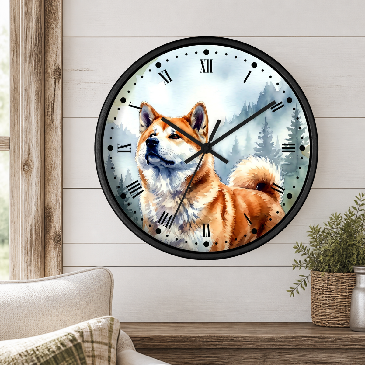 A round wall clock with a black frame and Roman numerals, featuring a printed illustration of an Akita dog in front of a misty pine forest. The clock is mounted on a white wood-paneled wall above a wooden table with a small potted plant.