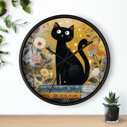 Decorative wall clock with a black cat design on a floral background, placed on a white wall with a plant and small pot in the foreground.