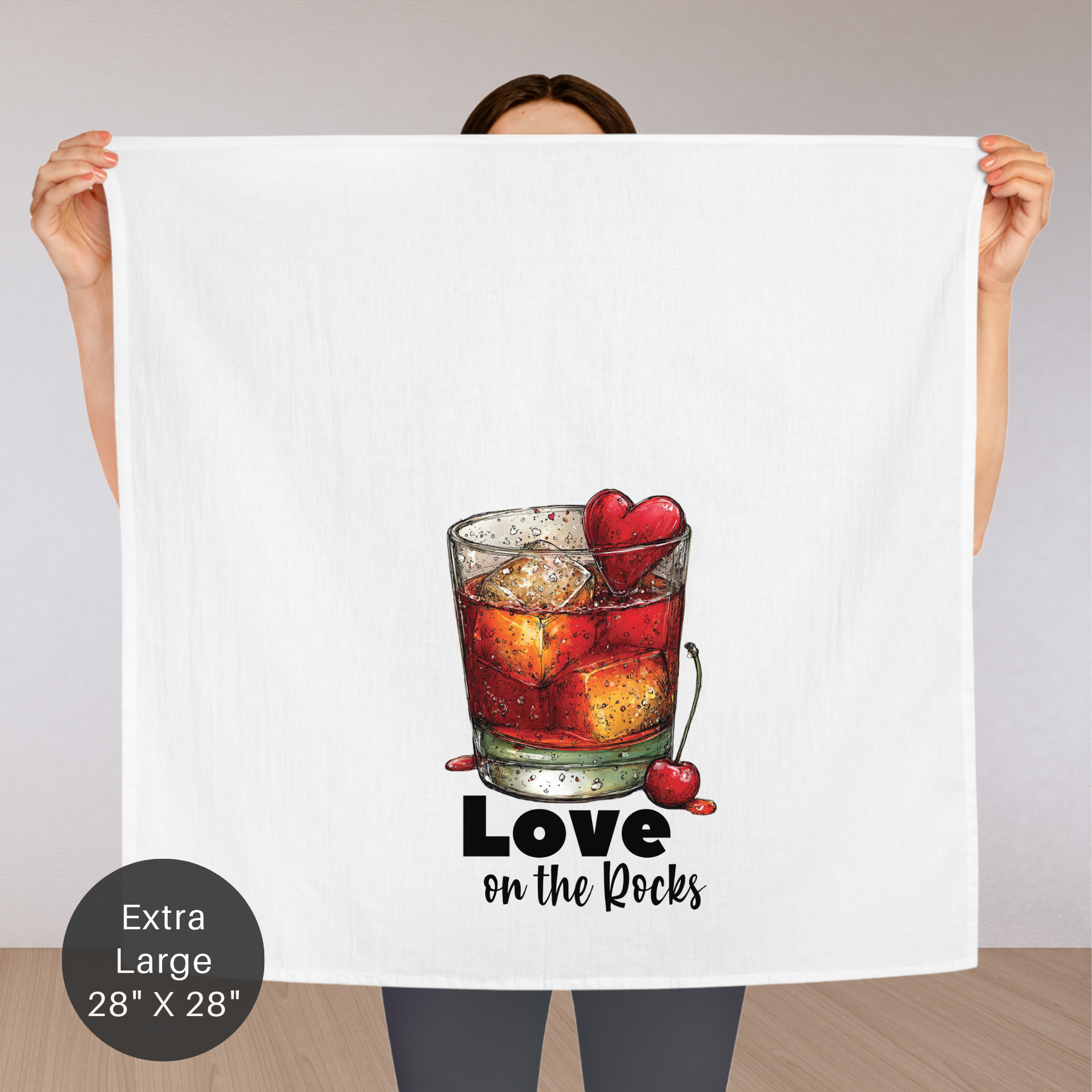 Person holding an extra large tea towel with a cocktail design and 'Love on the Rocks' text.