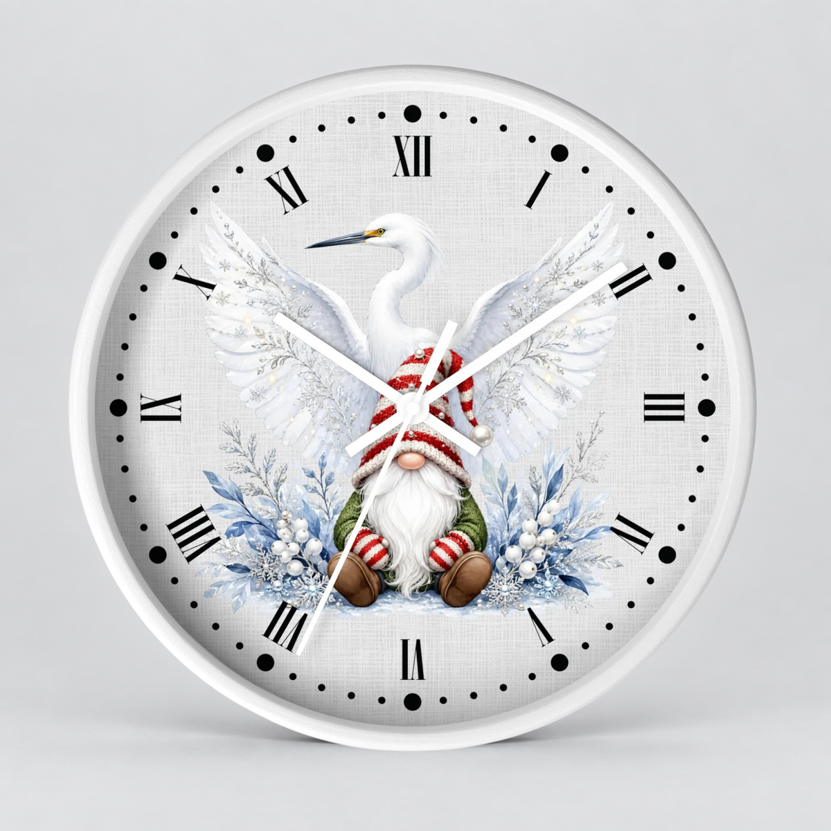 A round wall clock with a white face and white rim, featuring a festive illustration of a white heron with wings spread over a Christmas gnome wearing a red-and-white striped hat and green pants, surrounded by blue winter foliage. The clock uses black Roman numerals and white hands on a light gray background.